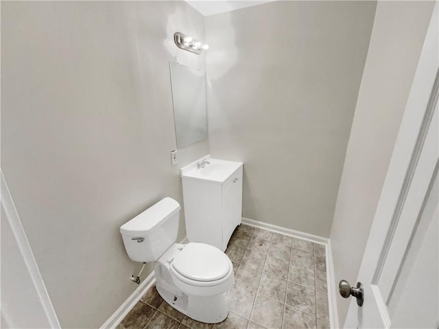 bathroom with tile patterned flooring, toilet, vanity, and baseboards