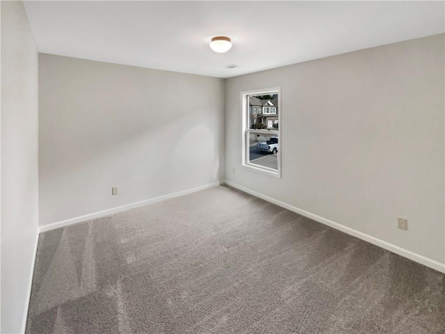 spare room featuring carpet and baseboards