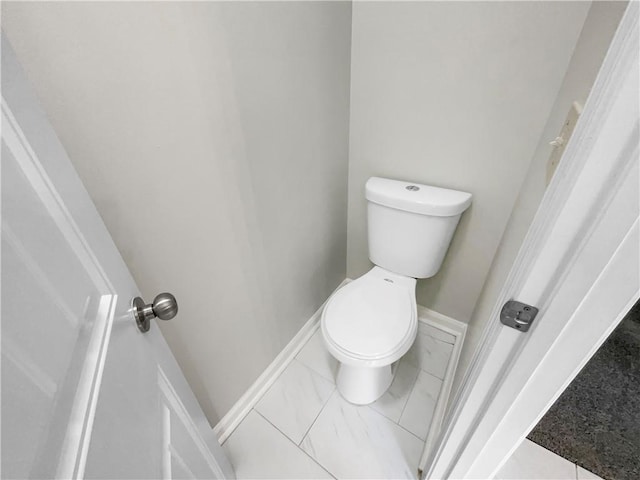 bathroom featuring baseboards and toilet