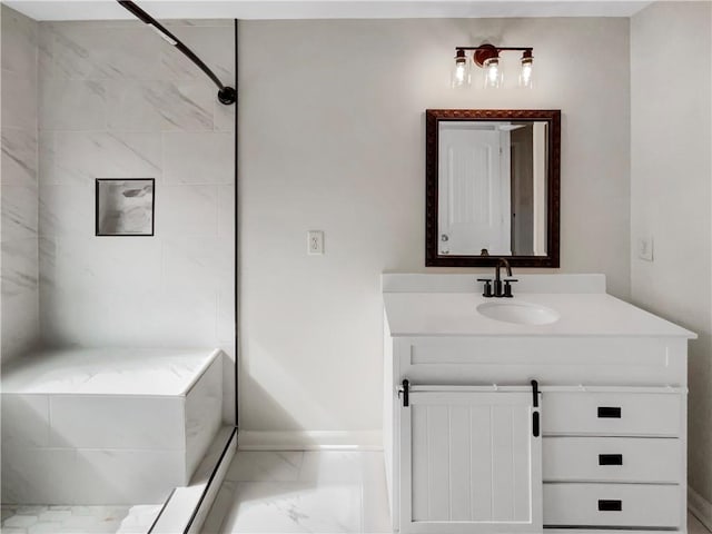 bathroom with marble finish floor, a shower stall, baseboards, and vanity