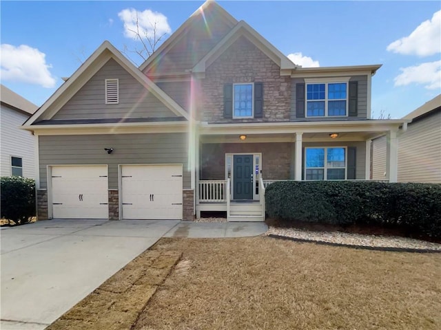 craftsman-style house with stone siding, covered porch, driveway, and an attached garage