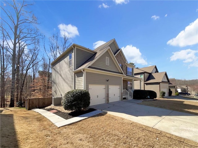 view of front of home featuring concrete driveway, an attached garage, fence, and a residential view