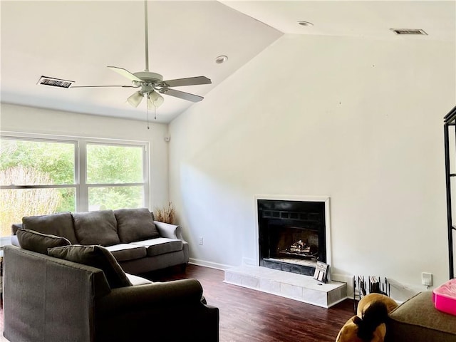 living room with a tile fireplace, dark hardwood / wood-style flooring, high vaulted ceiling, and ceiling fan