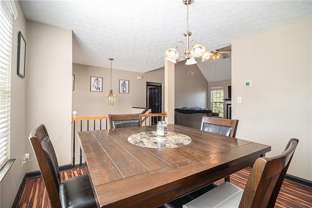 dining room with a notable chandelier, vaulted ceiling, a textured ceiling, and dark hardwood / wood-style floors