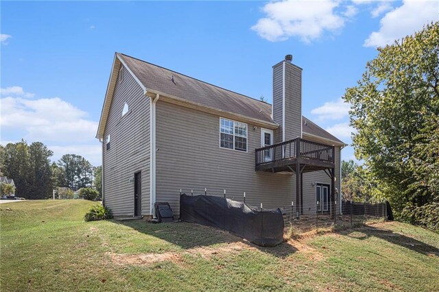 back of property with a lawn and a deck