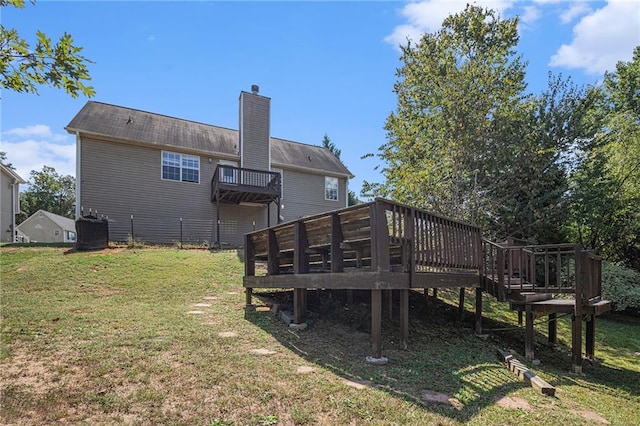 back of property featuring a wooden deck, central AC, and a yard