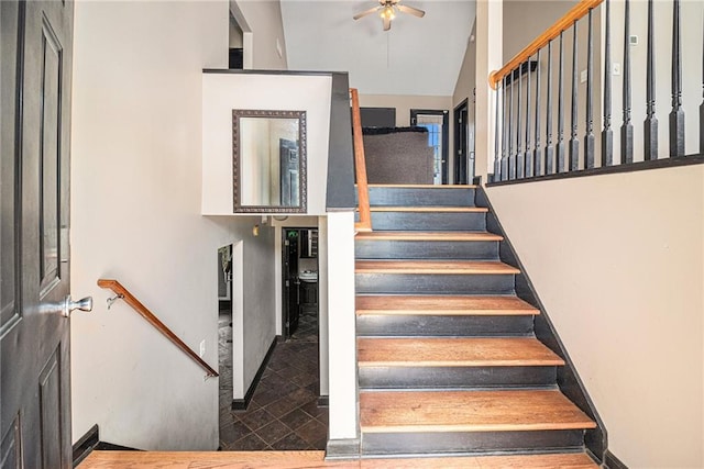 stairway featuring vaulted ceiling and ceiling fan