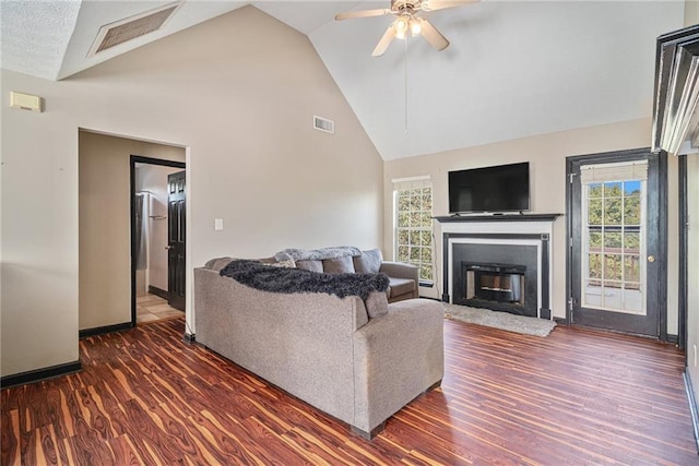 living room with high vaulted ceiling, ceiling fan, and dark wood-type flooring