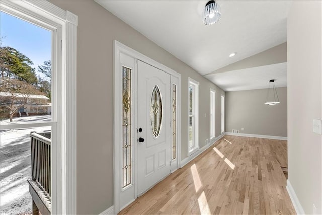 entryway featuring vaulted ceiling and light hardwood / wood-style flooring