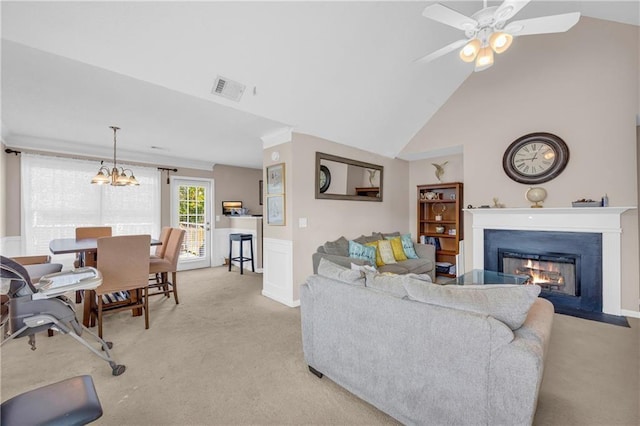 carpeted living room featuring lofted ceiling and ceiling fan with notable chandelier