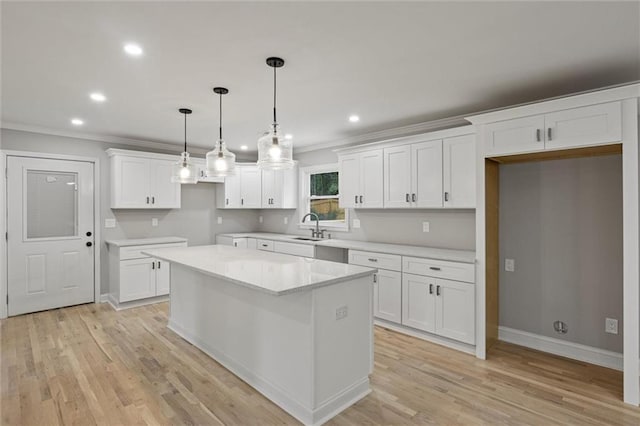 1320 Melbenan Dr, Atlanta, GA 30311 - kitchen with white cabinets, a sink, light wood-style floors, a kitchen island, and crown molding