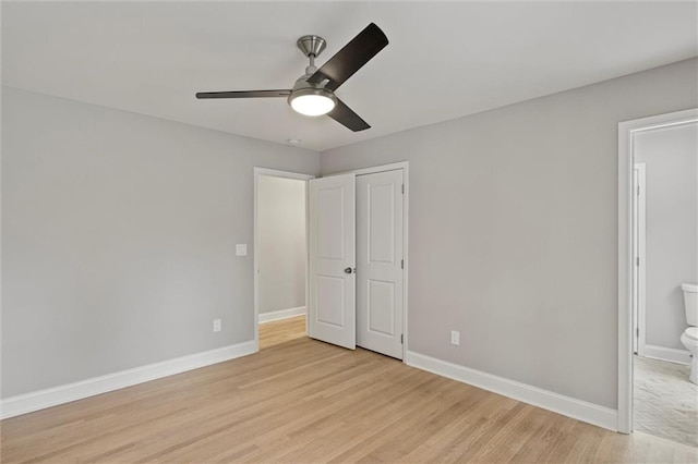 unfurnished bedroom featuring a closet, light hardwood / wood-style floors, ceiling fan, and ensuite bathroom