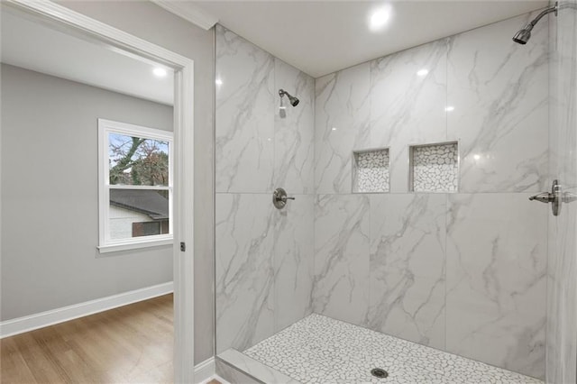 bathroom with tiled shower and hardwood / wood-style floors