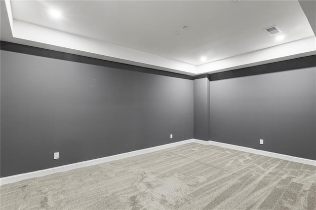 carpeted spare room with a tray ceiling