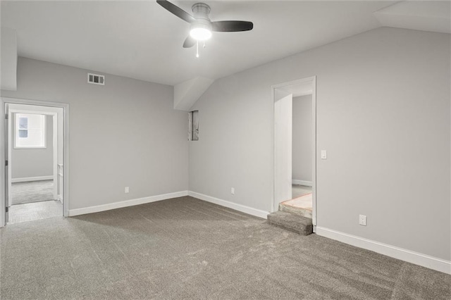 unfurnished room featuring carpet, vaulted ceiling, and ceiling fan