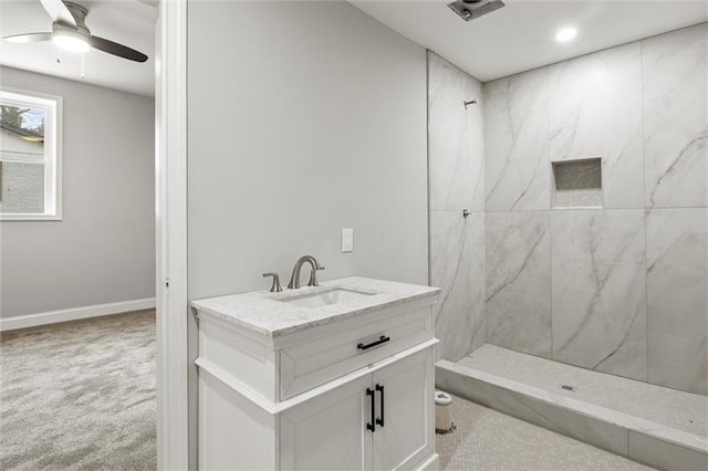 bathroom with a tile shower, vanity, and ceiling fan