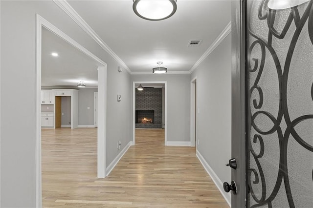 corridor featuring light wood-type flooring and crown molding