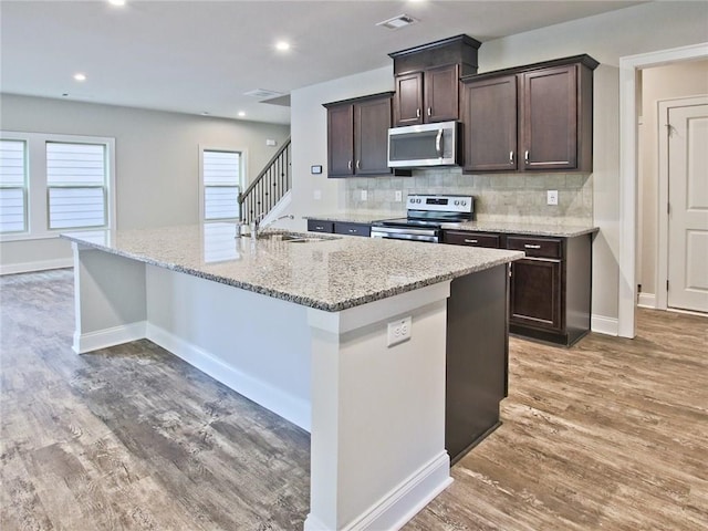 3305 Morgan Rd, Buford, GA 30519 - kitchen with stainless steel appliances, dark brown cabinets, a sink, an island with sink, and recessed lighting