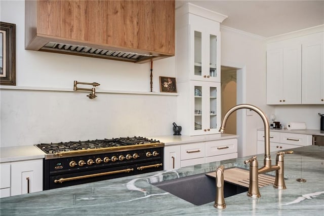 5102 Chastleton Dr, Stone Mountain, GA 30087 - kitchen with double oven range, a sink, glass insert cabinets, ornamental molding, and white cabinetry