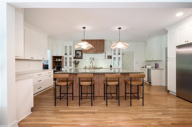 5102 Chastleton Dr, Stone Mountain, GA 30087 - kitchen with stainless steel refrigerator, a sink, light wood-style floors, white cabinetry, and glass insert cabinets