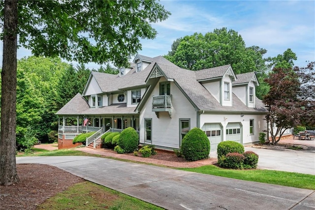 5102 Chastleton Dr, Stone Mountain, GA 30087 - view of front of home featuring driveway, covered porch, roof with shingles, and a balcony