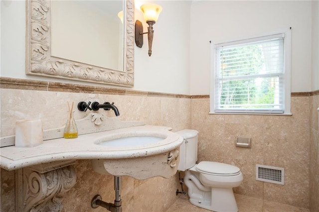 5102 Chastleton Dr, Stone Mountain, GA 30087 - bathroom with toilet, a wainscoted wall, tile walls, and tile patterned flooring