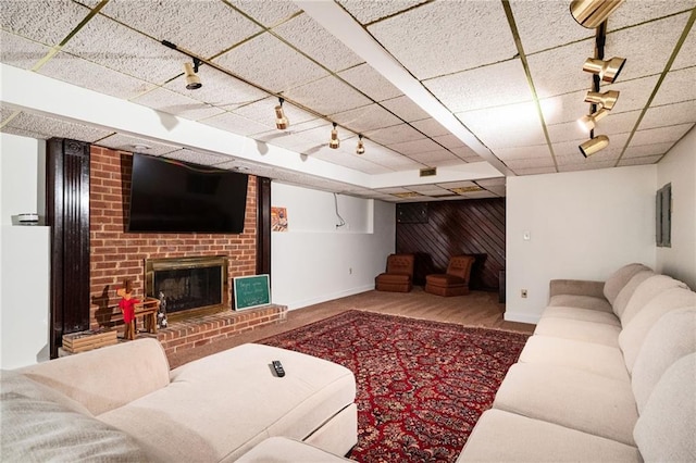 5102 Chastleton Dr, Stone Mountain, GA 30087 - living room with rail lighting, baseboards, a brick fireplace, and wood finished floors