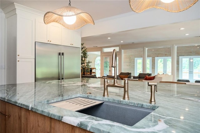 5102 Chastleton Dr, Stone Mountain, GA 30087 - kitchen featuring built in fridge, a sink, stone counters, french doors, and white cabinets