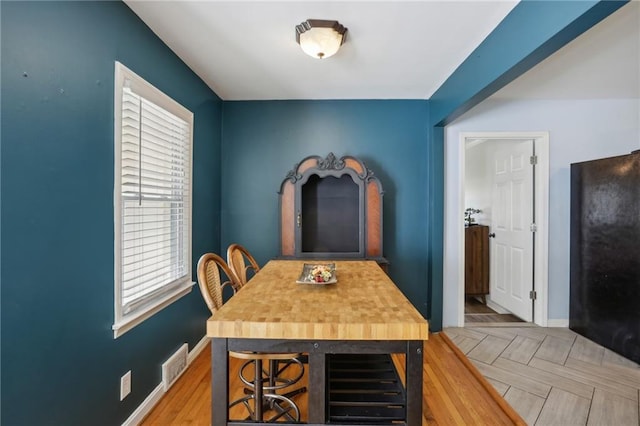 dining space featuring light parquet floors and a healthy amount of sunlight