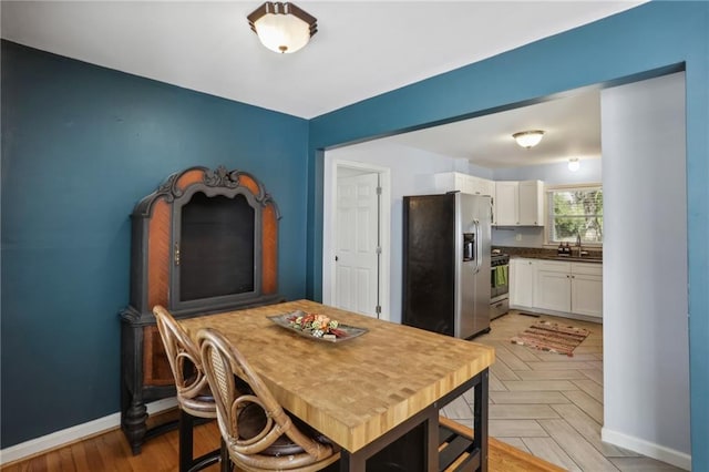 dining area with sink and light parquet flooring