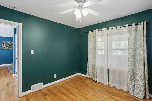 empty room with ceiling fan and hardwood / wood-style floors