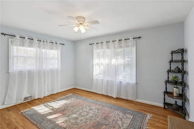 unfurnished room featuring ceiling fan, hardwood / wood-style floors, and plenty of natural light