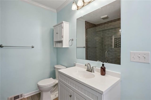 bathroom with ornamental molding, vanity, a shower with shower door, and toilet