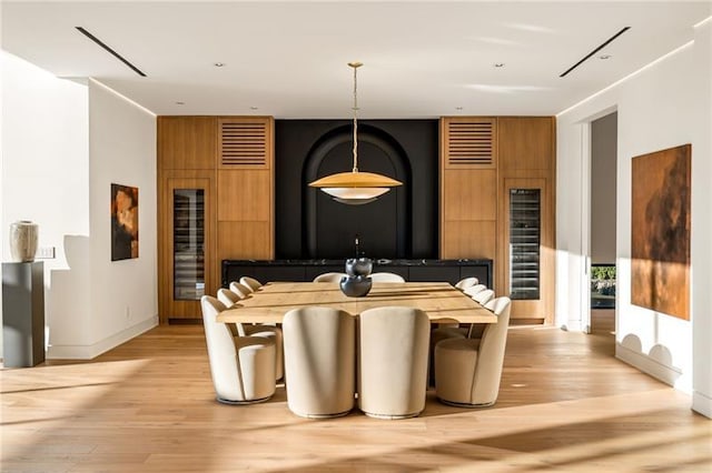 dining area featuring visible vents, baseboards, and light wood finished floors