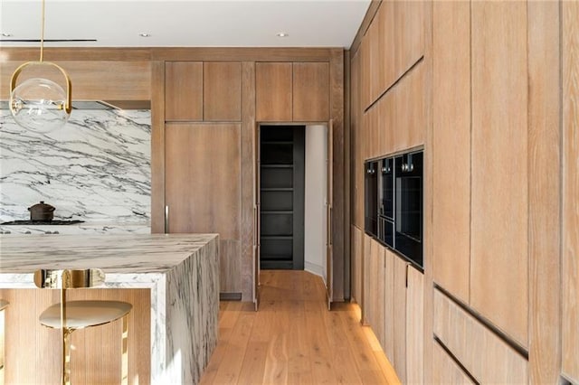 kitchen with light wood finished floors, modern cabinets, and light countertops