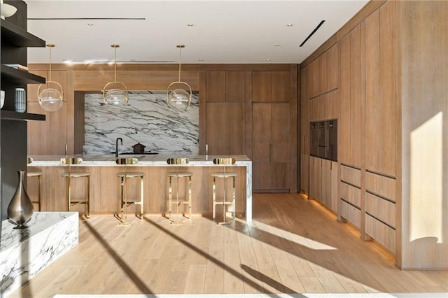 kitchen featuring brown cabinetry, decorative backsplash, modern cabinets, and open shelves