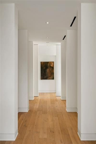 hall with light wood-type flooring and baseboards