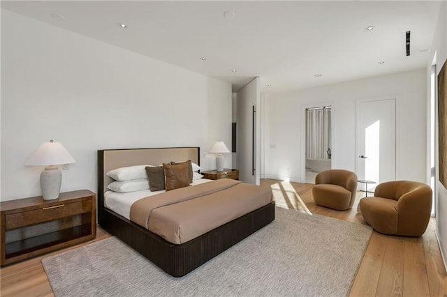 bedroom with recessed lighting and wood finished floors