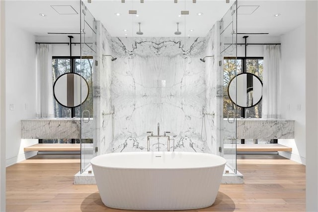 bathroom featuring recessed lighting, a marble finish shower, a soaking tub, and wood finished floors