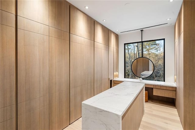 spacious closet featuring light wood-style flooring and built in desk