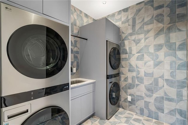 washroom with cabinet space and stacked washer and dryer