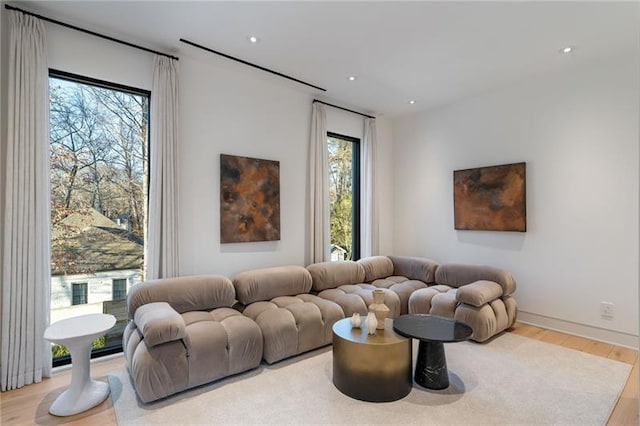 living area featuring a wealth of natural light, wood finished floors, and recessed lighting