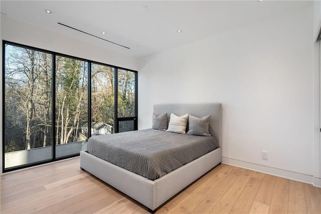 bedroom featuring recessed lighting, hardwood / wood-style floors, and access to exterior