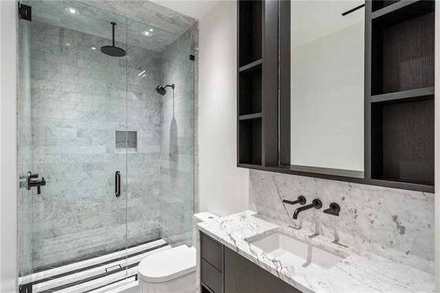 bathroom with decorative backsplash, a stall shower, toilet, and vanity