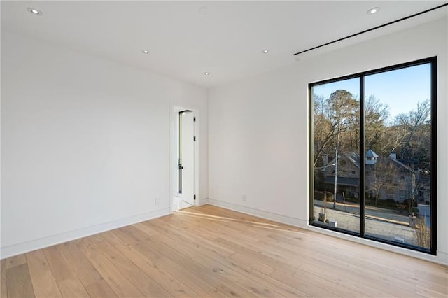 empty room with recessed lighting, baseboards, and light wood finished floors