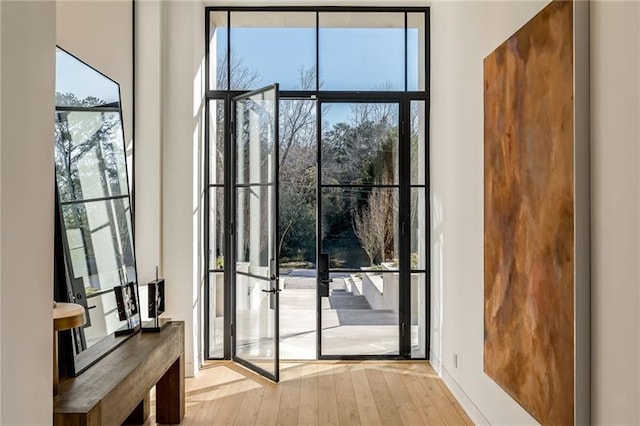 doorway to outside featuring hardwood / wood-style flooring and expansive windows