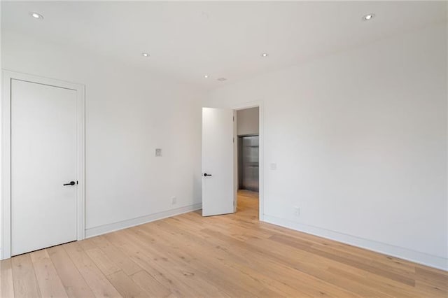 unfurnished bedroom with recessed lighting, baseboards, and light wood-style floors