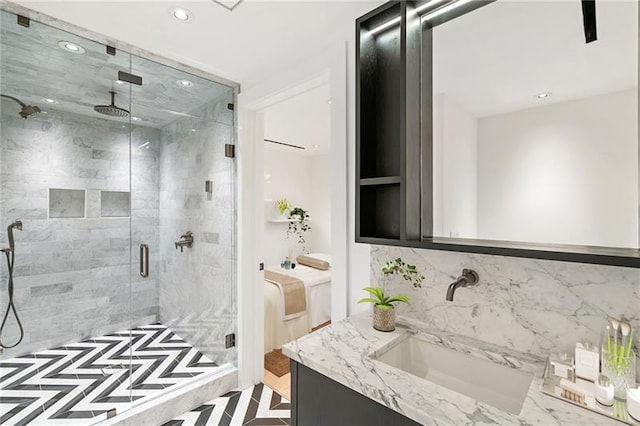 bathroom with recessed lighting, decorative backsplash, a stall shower, and vanity