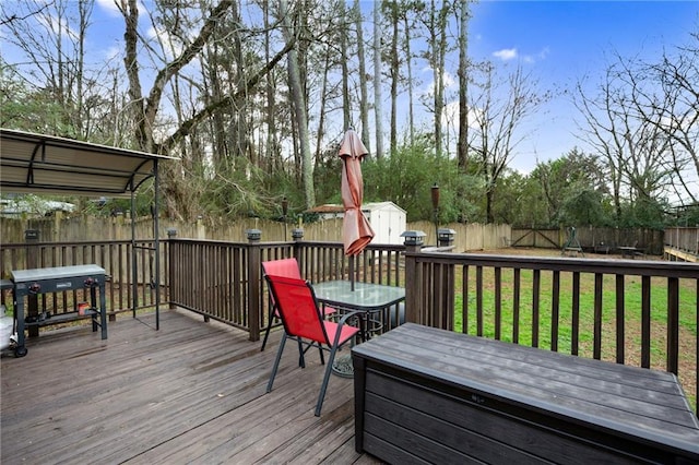 wooden terrace with a lawn and a storage shed