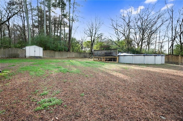 view of yard with a shed and a swimming pool side deck